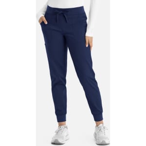 Navy jogger pants with a drawstring waist and side pockets, paired with a long-sleeved top and trainers.