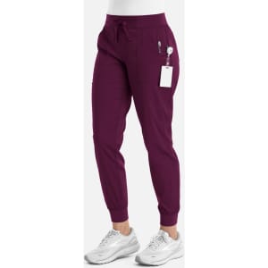 A pair of women's jogger pants in burgundy with elastic cuffs and pockets, featuring a logo.