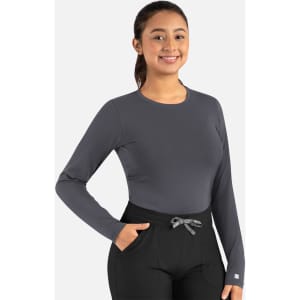 A long-sleeved, grey underscrub tee paired with black pants, featuring a logo on the sleeve.