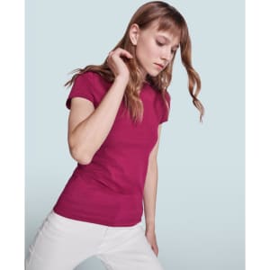A fitted maroon T-shirt worn by a model with long hair, styled in a casual pose. The background is light blue.