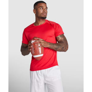 A red T-shirt displayed on a model holding a football, featuring short sleeves and a sleek fit.