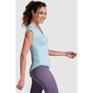 A light blue Jada T-Shirt worn by a smiling model, paired with purple leggings, showcasing a casual style.