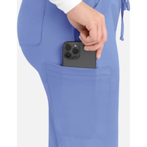 A close-up of light blue cargo pants with a smartphone being placed in the side pocket.