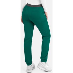 A woman is wearing teal cargo pants with a contrasting waistband, featuring a side pocket and elastic cuffs.