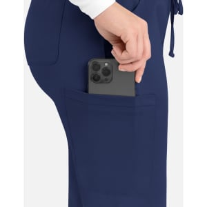 A close-up of navy cargo pants with a smartphone tucked into the side pocket. The pants feature a logo.