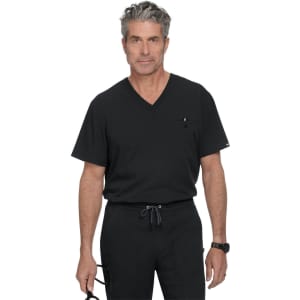 A man in a black V-neck scrub top stands confidently, wearing black trousers and holding glasses. The outfit features a pocket and branding.