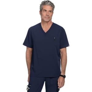 A navy v-neck scrub top featuring a chest pocket and a subtle logo. The model stands confidently in the garment.