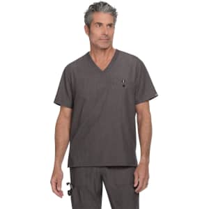 A man in a charcoal grey scrub top with a V-neck and a chest pocket, wearing coordinating scrub pants.