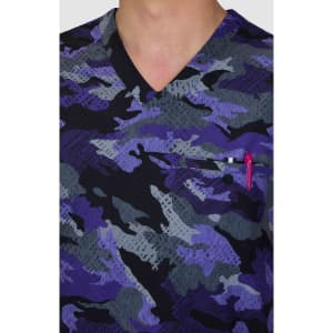 A scrub top featuring a purple and grey camouflage design with a v-neck and a chest pocket holding a pen.
