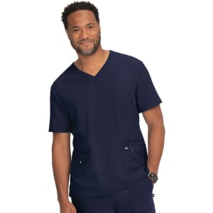A navy scrubs top featuring a V-neckline and two front pockets, worn by a smiling male model.