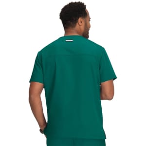 A scrub top in a vibrant teal colour, featuring a back view of a male model wearing it.