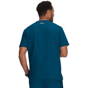 A scrub top in a deep teal colour, featuring a simple design and a logo on the back.