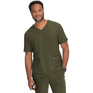 A medical scrub top in olive green, featuring a V-neck design and two front pockets. The model is smiling and wearing a watch.