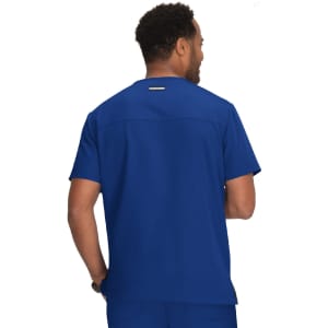 A man wearing a blue scrub top seen from the back, featuring a logo on the upper back.