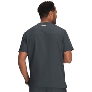 A man is wearing a dark grey medical scrubs top, viewed from the back, featuring a logo.