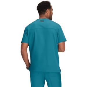 A turquoise medical scrub top featuring a logo on the back, worn by a person facing away.
