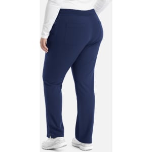 A pair of navy tapered yoga pants with a back pocket and logo detail, styled with white footwear.