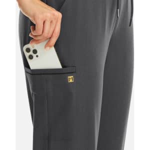 A pair of grey joggers with a pocket holding a smartphone, featuring a small logo.