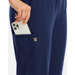 A pair of navy joggers featuring metallic detail, with a smartphone being held in a side pocket.