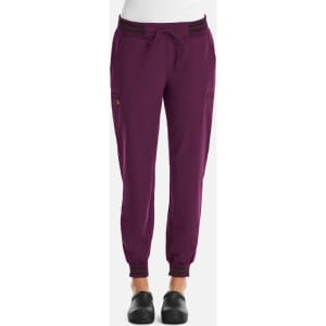 A pair of women's jogger trousers in purple, featuring metallic detail and cuffs at the ankles, alongside a logo.