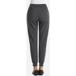 A pair of women's full waist joggers in dark grey, featuring a smooth back and ankle cuffs. It includes pockets and a logo.