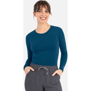 A fitted long-sleeve tee in deep teal, paired with grey drawstring pants. The tee features a logo on one sleeve.