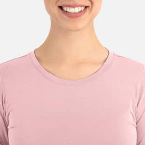 A close-up of a woman's neckline wearing a light pink underscrub tee. The tee features a round neckline.