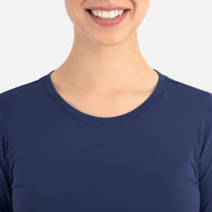 A close-up of a woman wearing a navy blue underscrub tee, featuring a round neck and no visible branding.