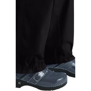 A pair of black pants and blue clogs, featuring a logo on the clogs.