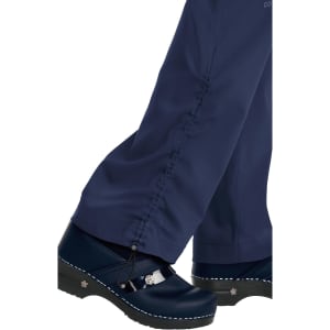 A pair of navy blue pants with a cinched hem, paired with footwear featuring a decorative detail and a light sole.