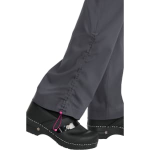 A pair of grey pants with a cinched hem, paired with black clogs featuring a decorative element.