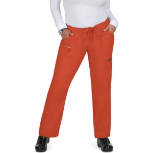 An individual wearing bright orange pants with pockets and a drawstring waist, standing with hands in pockets.