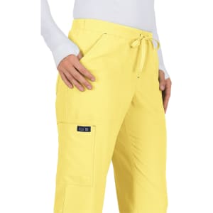 A pair of yellow pants with a drawstring waist and side pockets, featuring a small logo on the leg.