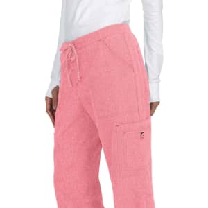 Pink pants with a textured fabric and a drawstring waistband, featuring side pockets and a branding logo.