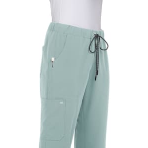 Light green pants with an elastic waistband, side pockets, and a drawstring detail. The product includes a logo.