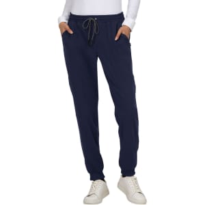 A pair of navy jogger pants with a drawstring waist and side pockets, worn with a long-sleeve white top.
