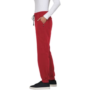 Red jogger pant displayed on a model, featuring side pockets and a drawstring waist, paired with a white long-sleeve top.