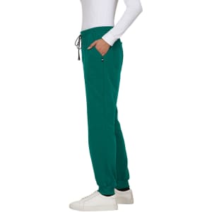 A green jogger pant with pockets and a drawstring waistband, styled with a fitted top and white sneakers.