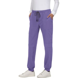 A pair of purple jogger pants with side pockets and drawstring waist, styled with a white long-sleeve top and white sneakers.