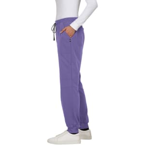 A pair of purple jogger pants with pockets and a drawstring waistband, worn with white sneakers.