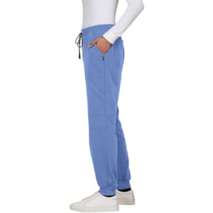 A pair of blue jogger pants with pockets and a drawstring, worn with white shoes. Features a small logo.