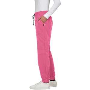 A pair of pink jogger pants with pockets and a drawstring waist, worn with white sneakers. Features branding.