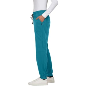 A pair of teal jogger pants with pockets and an elastic waistband, worn with white sneakers.