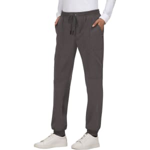 A pair of grey jogger pants with pockets and an elastic waistband, styled with a white top and sneakers.