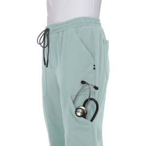 A pair of light mint jogger pants featuring side pockets, one holding a stethoscope, and a drawstring waist.