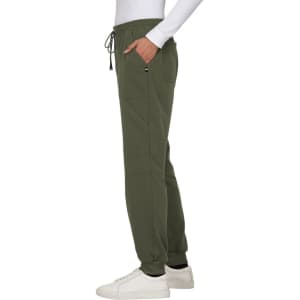 A pair of olive green jogger pants with pockets and a drawstring waistband, worn with a white long-sleeve top.