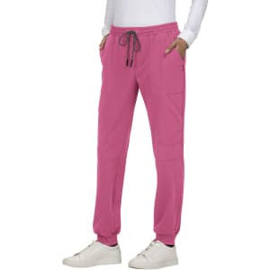 A pair of pink jogger pants with pockets and an elastic waistband, modelled by a person wearing a white top and shoes.