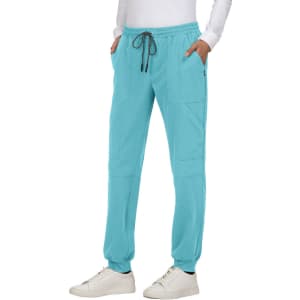A pair of turquoise jogger pants with pockets and a drawstring waist, featuring a logo.