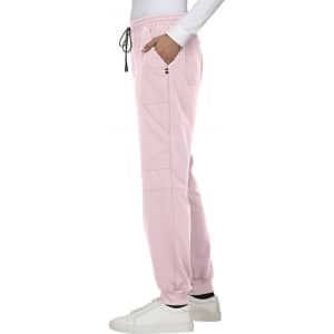 A pink jogger pant with a drawstring waist, featuring pockets and a logo, displayed on a model.