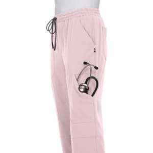A pair of light pink jogger pants with pockets, featuring a stethoscope tucked into one of the pockets.